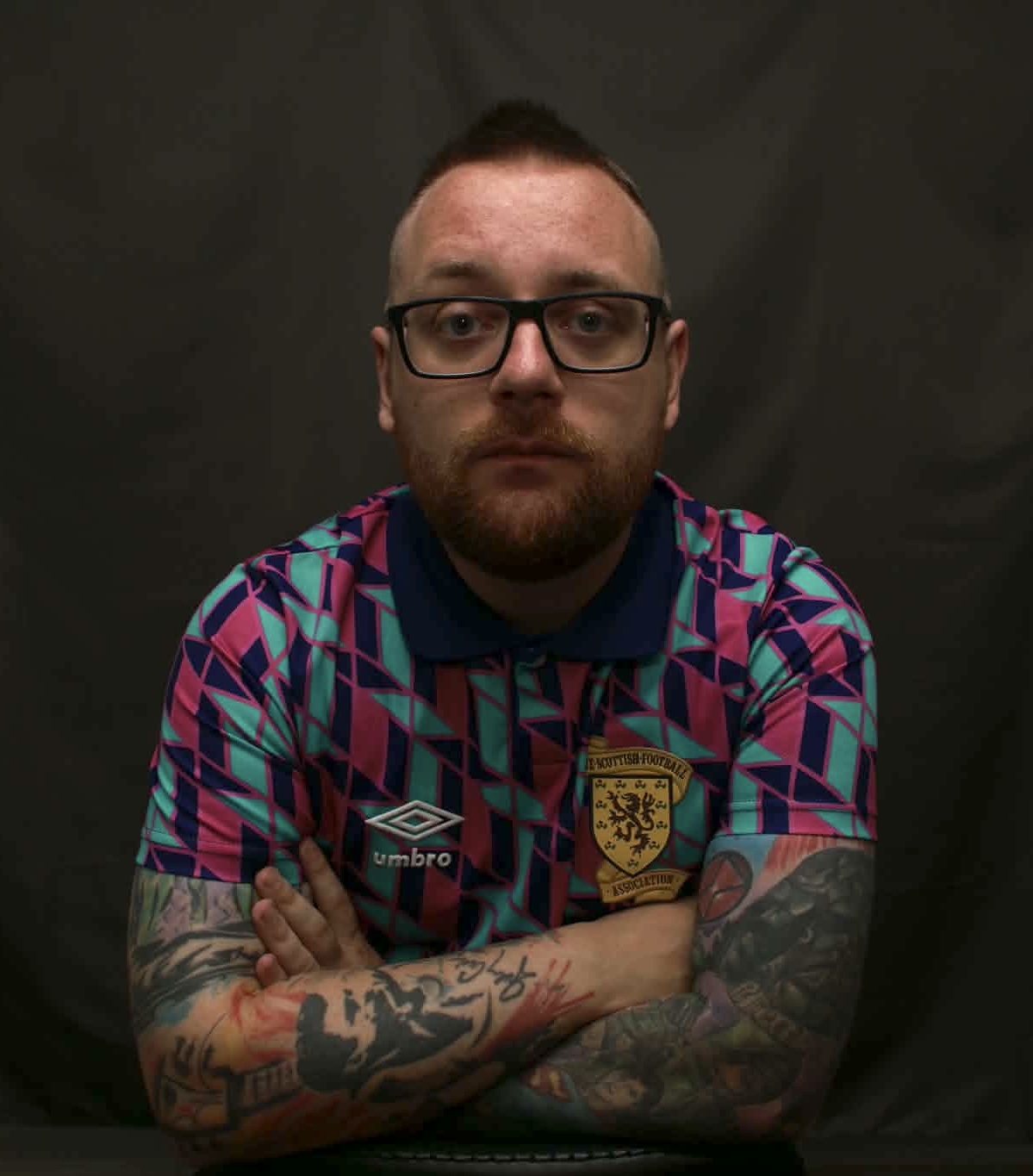Studio portrait of Joe Quinn, arms folded